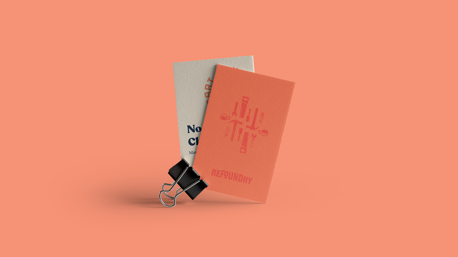 Two cards clipped together with a black binder clip against a peach-colored background. The front card is partially obscured and has the text ‘No’ visible. The back card is orange with white text that reads ‘REPOSITORY’ and features a graphic of an upside-down flask with the same word inside it